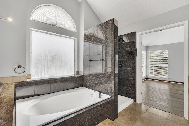 bathroom featuring shower with separate bathtub, vaulted ceiling, a textured ceiling, and hardwood / wood-style flooring