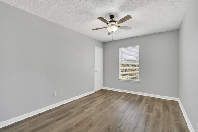 empty room with ceiling fan, hardwood / wood-style floors, and a textured ceiling