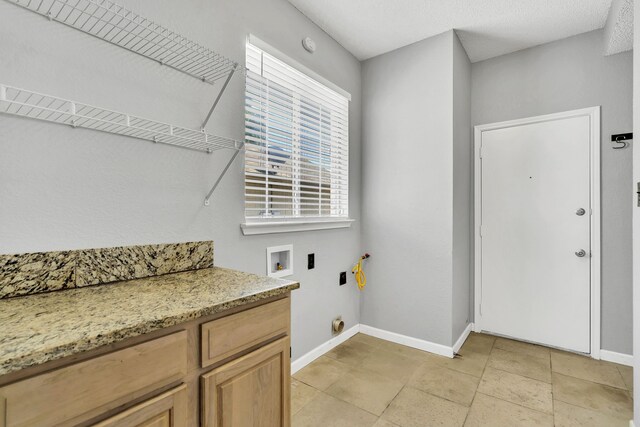 washroom with washer hookup, electric dryer hookup, and cabinets