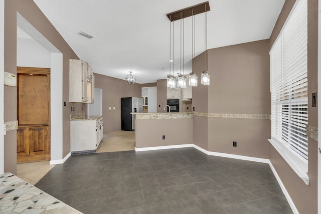 kitchen featuring stainless steel refrigerator with ice dispenser, dark tile patterned flooring, hanging light fixtures, and lofted ceiling