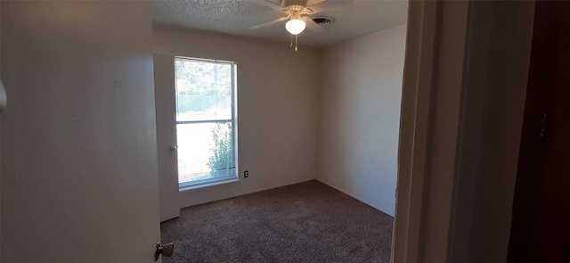 unfurnished room featuring a textured ceiling, carpet, and ceiling fan