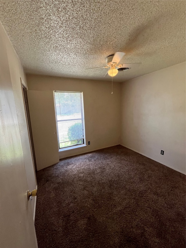 carpeted spare room featuring ceiling fan and a textured ceiling