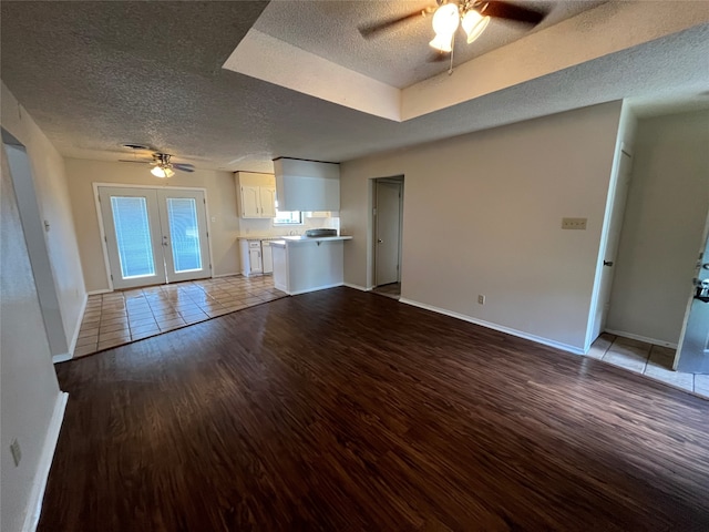 unfurnished living room with ceiling fan, a textured ceiling, and light hardwood / wood-style flooring