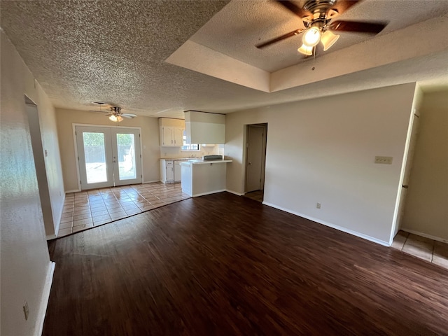 unfurnished living room with light wood-type flooring, ceiling fan, and a textured ceiling