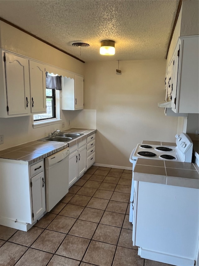 kitchen with white cabinets, light tile patterned flooring, sink, white appliances, and tile countertops