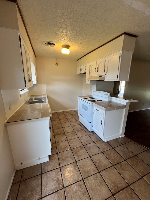 kitchen featuring white cabinetry, a textured ceiling, tile patterned flooring, white range with electric cooktop, and sink