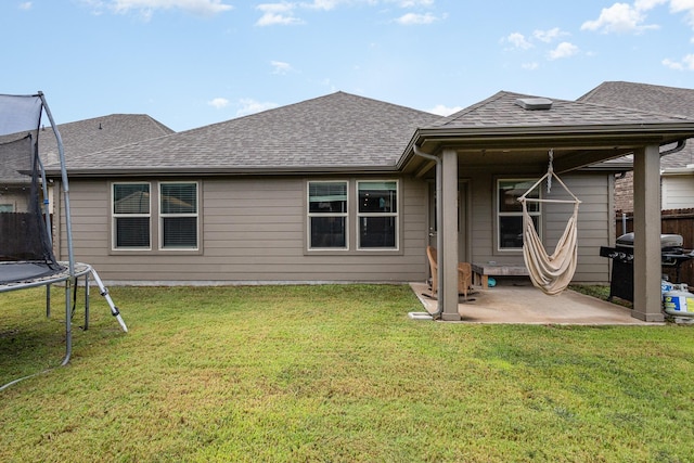 641 Fletcher Dr, Fate, TX 75087 - rear view of property featuring fence, a patio area, a lawn, roof with shingles, and a trampoline
