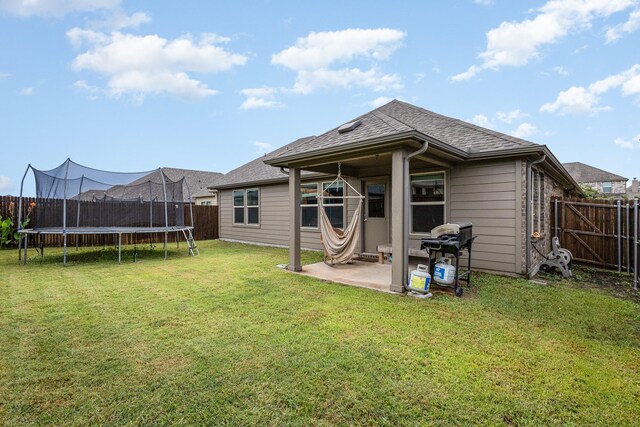 641 Fletcher Dr, Fate, TX 75087 - back of house featuring a yard, a trampoline, a fenced backyard, and a patio