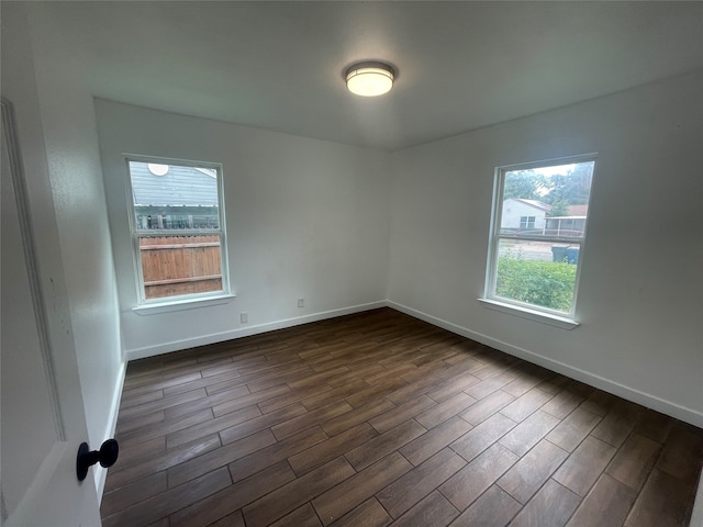 spare room with a healthy amount of sunlight and dark hardwood / wood-style flooring