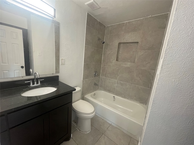 full bathroom featuring tiled shower / bath combo, vanity, toilet, and tile patterned floors