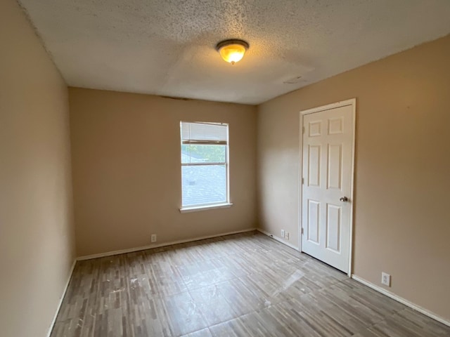 empty room featuring light hardwood / wood-style floors and a textured ceiling