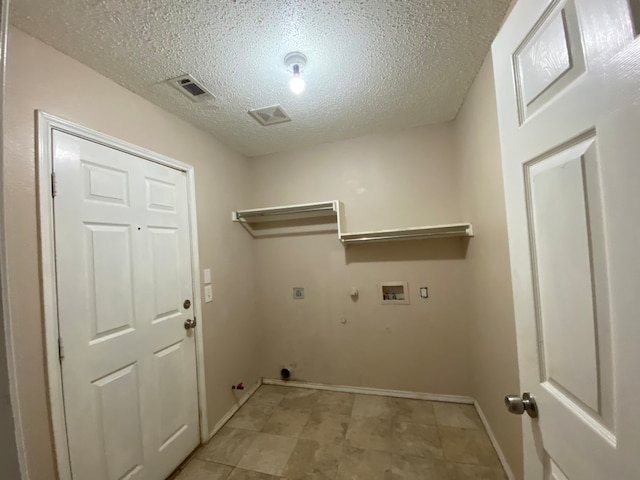 washroom with hookup for a washing machine, gas dryer hookup, a textured ceiling, and hookup for an electric dryer