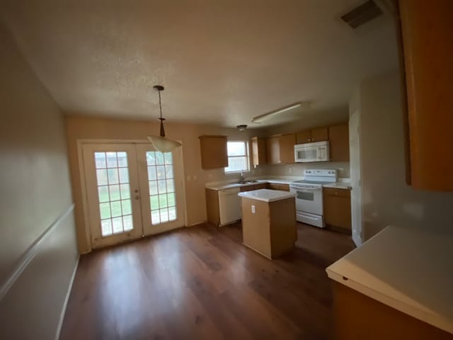 kitchen featuring dark hardwood / wood-style floors, sink, a kitchen island, white appliances, and decorative light fixtures