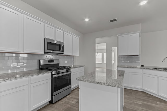 kitchen with a kitchen island, light hardwood / wood-style flooring, stainless steel appliances, and white cabinets