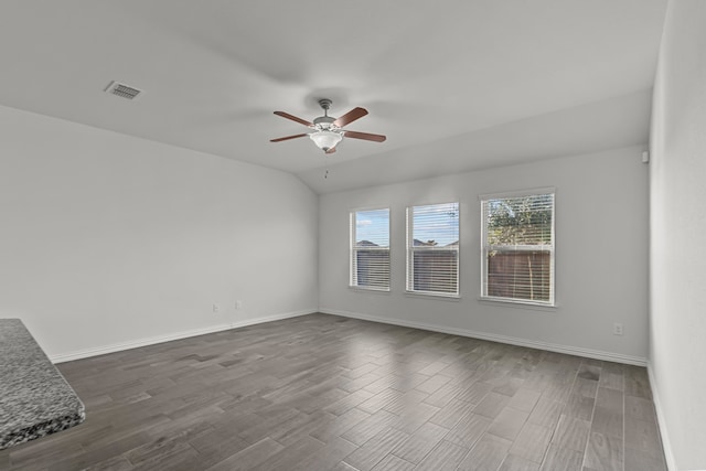 empty room with ceiling fan, lofted ceiling, and dark hardwood / wood-style floors