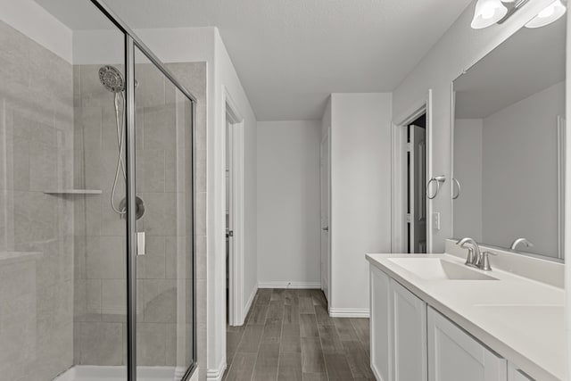 bathroom with vanity, hardwood / wood-style flooring, and a shower with shower door