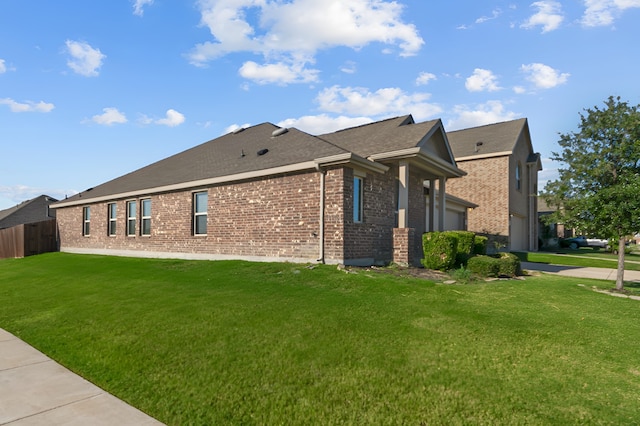 view of side of property featuring a garage and a yard