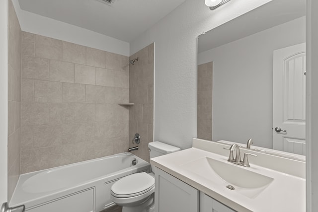 full bathroom featuring vanity, tiled shower / bath combo, and toilet