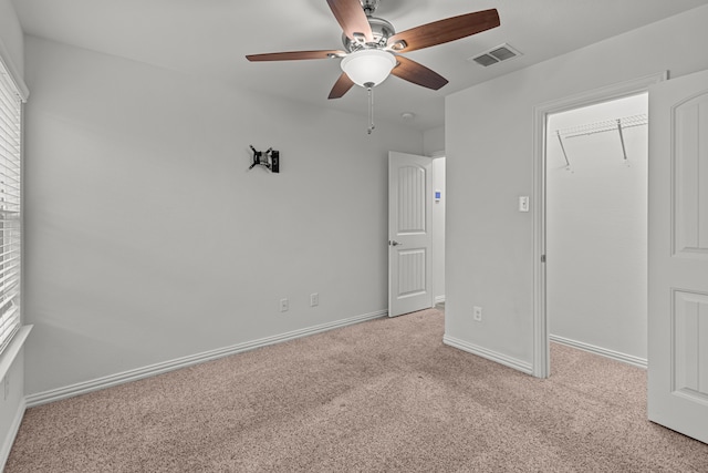 interior space featuring ceiling fan, light colored carpet, and a closet