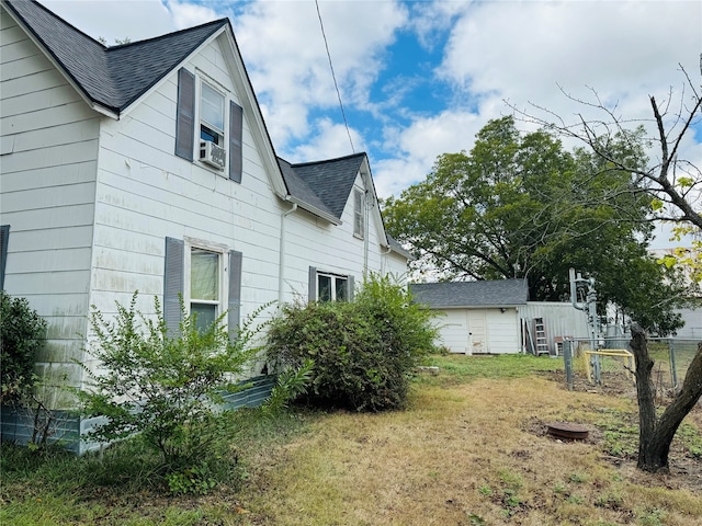 view of side of home with cooling unit and a lawn