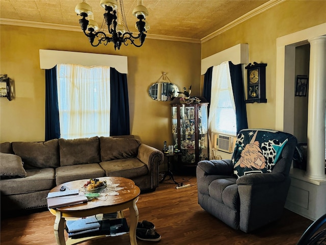 living room featuring an inviting chandelier, crown molding, hardwood / wood-style floors, and ornate columns