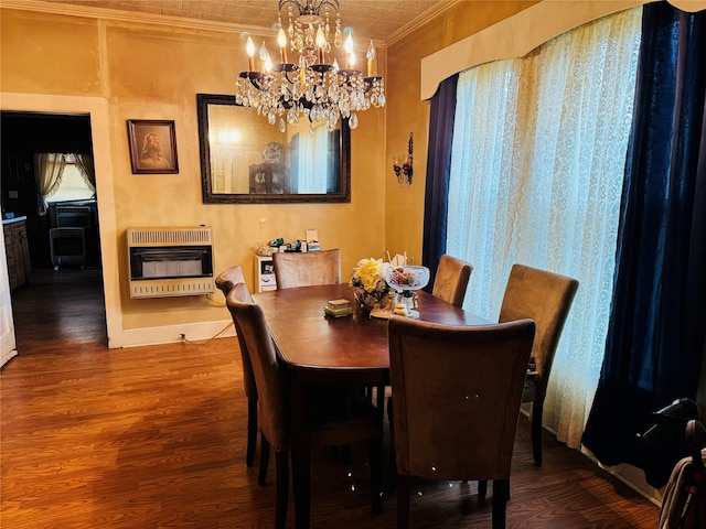 dining room with hardwood / wood-style flooring, crown molding, heating unit, and a notable chandelier