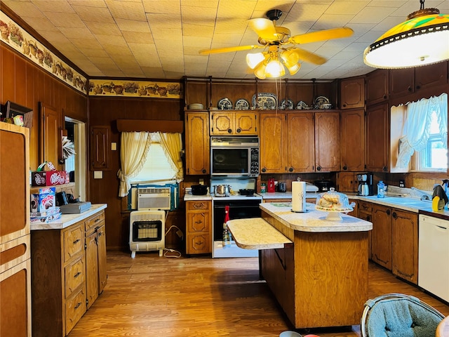 kitchen with a wealth of natural light, white appliances, ceiling fan, and a kitchen island