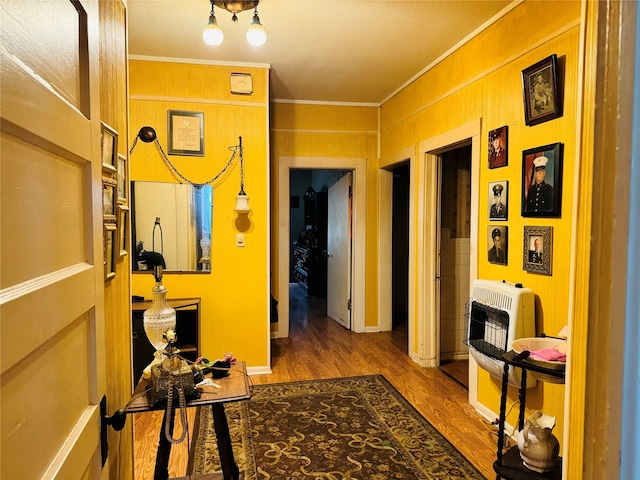 hallway featuring ornamental molding, hardwood / wood-style floors, and heating unit