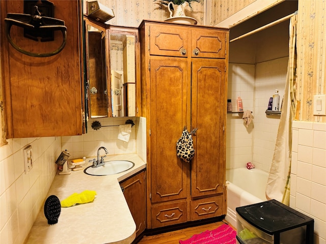 bathroom featuring shower / bath combo, hardwood / wood-style flooring, vanity, and tasteful backsplash