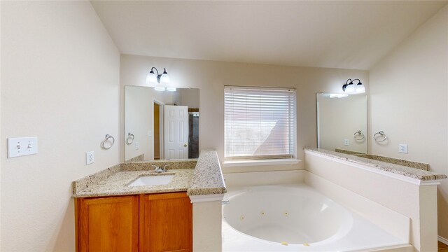 bathroom featuring a washtub and vanity