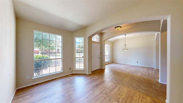 foyer featuring lofted ceiling, hardwood / wood-style floors, and a wealth of natural light