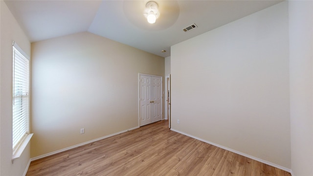 spare room featuring light hardwood / wood-style flooring and vaulted ceiling