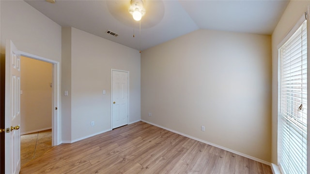 spare room featuring ceiling fan, lofted ceiling, and light hardwood / wood-style floors