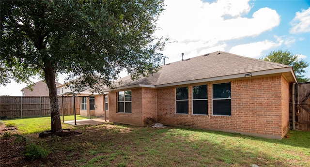 rear view of house featuring a lawn and a patio area