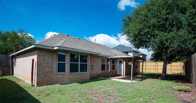 back of house featuring a lawn and a patio