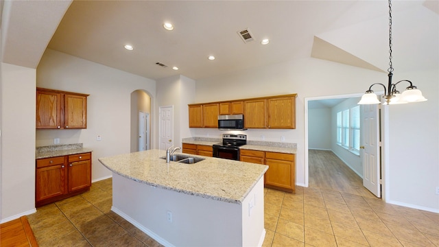 kitchen featuring an island with sink, lofted ceiling, sink, stainless steel appliances, and a notable chandelier