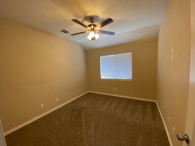 unfurnished room with dark colored carpet and ceiling fan