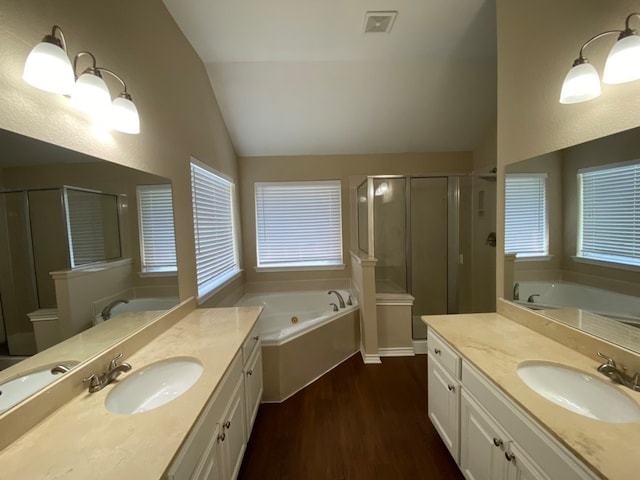 bathroom with shower with separate bathtub, vaulted ceiling, hardwood / wood-style flooring, and vanity