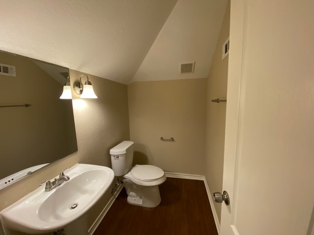 bathroom with lofted ceiling, toilet, sink, and hardwood / wood-style flooring