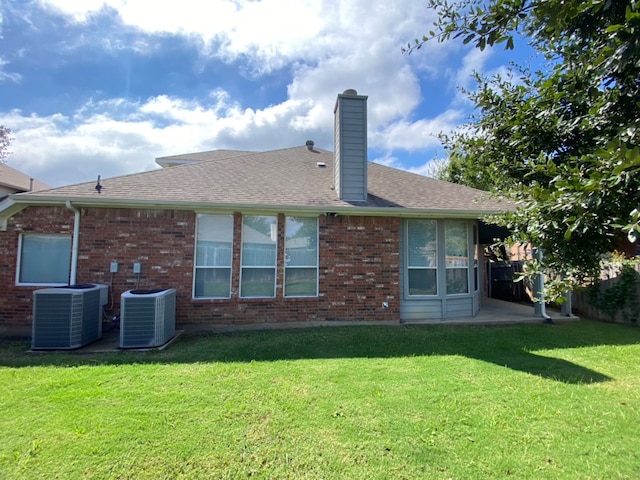 back of house featuring a lawn and central AC