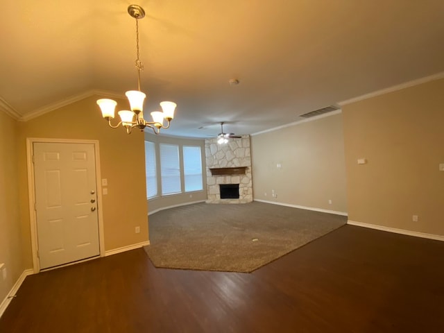 unfurnished living room featuring ceiling fan with notable chandelier, a stone fireplace, dark hardwood / wood-style flooring, lofted ceiling, and ornamental molding