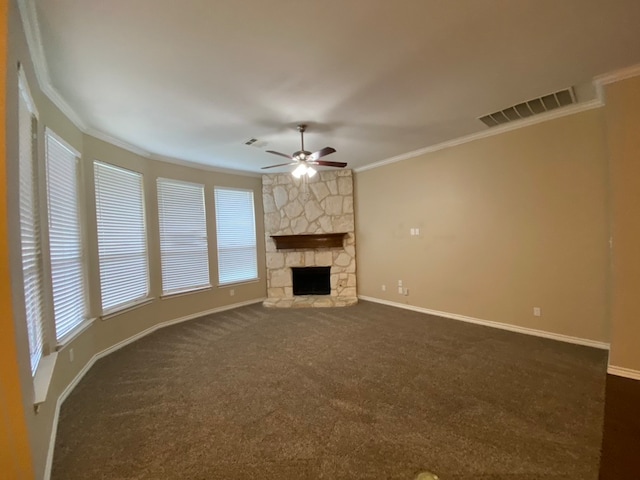 unfurnished living room with crown molding, a fireplace, dark colored carpet, and ceiling fan