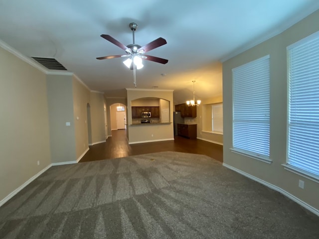 unfurnished living room featuring ceiling fan with notable chandelier, ornamental molding, and dark colored carpet