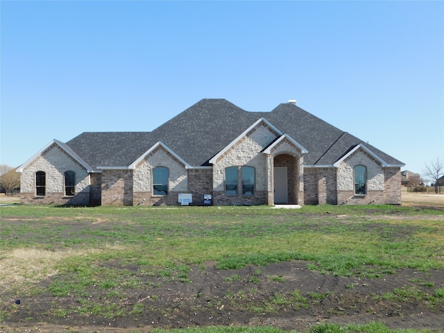 french country inspired facade with a front lawn