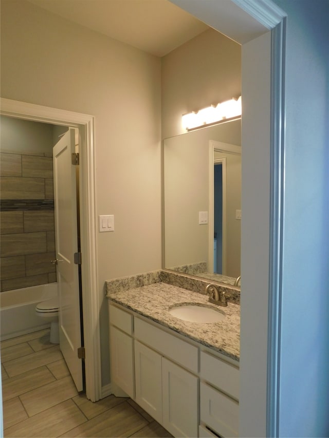 full bathroom with vanity, toilet, and washtub / shower combination