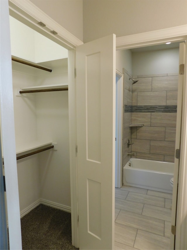 bathroom featuring tiled shower / bath and toilet