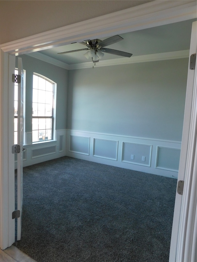 empty room with ceiling fan, ornamental molding, and carpet flooring