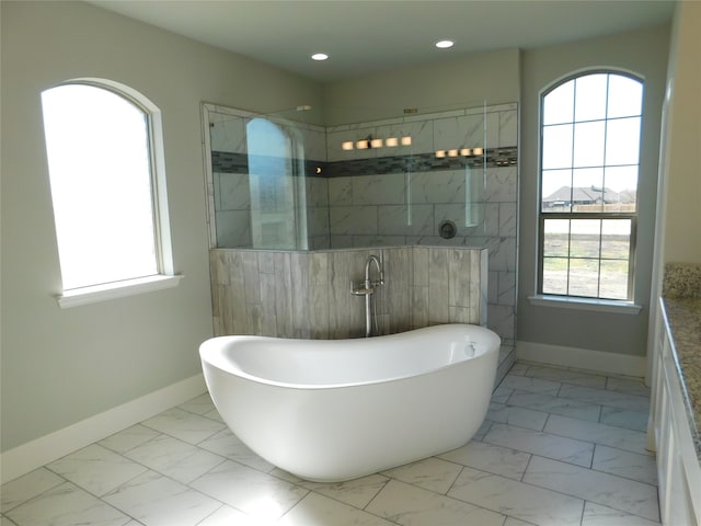 bathroom featuring independent shower and bath and a healthy amount of sunlight