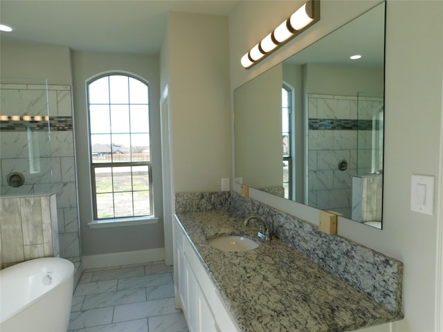 bathroom featuring plus walk in shower, a wealth of natural light, and vanity