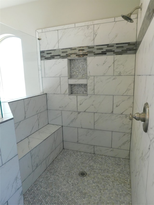 bathroom featuring tiled shower and plenty of natural light